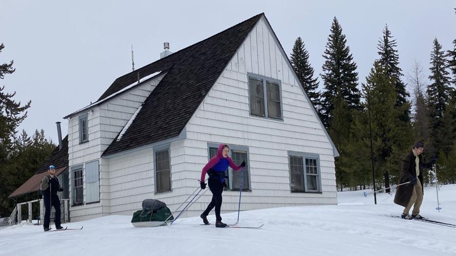 Skiiers cross the front yard of the Blue Mountain Cabin